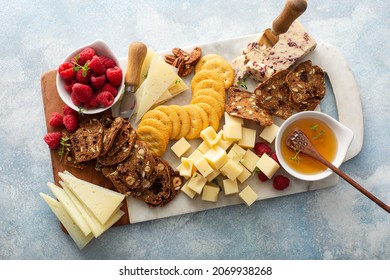 Cheese board or snack board with crackers, nuts and berries - Powered by Shutterstock