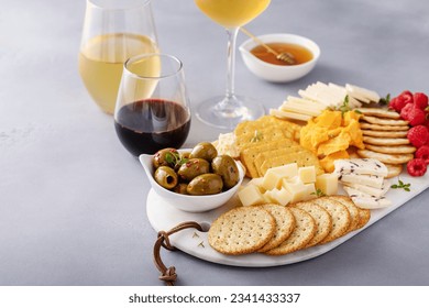 Cheese board or snack board with crackers, cheese, olives and raspberries - Powered by Shutterstock