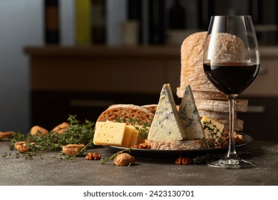 Cheese, bread, red wine, and walnuts on a kitchen table. In the background various wine bottles. Selective focus. - Powered by Shutterstock