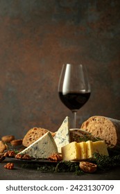 Cheese, bread, red wine, and walnuts on a stone table. Traditional Mediterranean snacks.