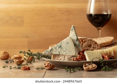 Cheese, bread, red wine, and walnuts on a kitchen table. Traditional Mediterranean snacks. Copy space.