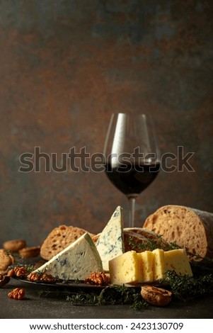 Cheese, bread, red wine, and walnuts on a stone table. Traditional Mediterranean snacks.