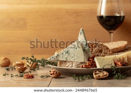 Cheese, bread, red wine, and walnuts on a kitchen table. Traditional Mediterranean snacks. Copy space.