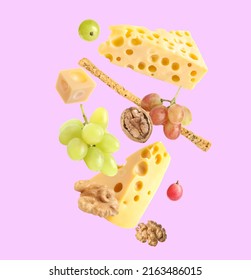 Cheese, Breadstick, Grapes And Walnuts Falling Against Violet Background