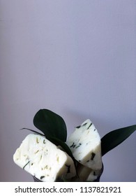 Cheese Bricks On White Background With Italian Ruscus Leaves