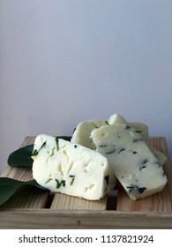 Cheese Bricks On White Background With Italian Ruscus Leaves