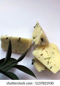 Cheese Bricks On White Background With Italian Ruscus Leaves