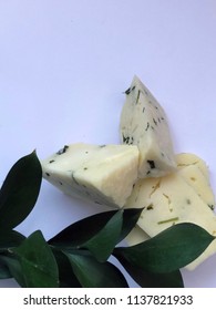 Cheese Bricks On White Background With Italian Ruscus Leaves