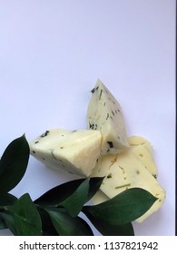 Cheese Bricks On White Background With Italian Ruscus Leaves