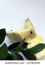 Cheese Bricks On White Background With Italian Ruscus Leaves