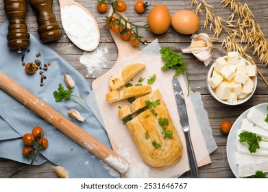 Cheese burek on Wooden Board with Rustic Cooking Ingredients. Puff Pastry and Fresh Ingredients Ready for Cooking, Rustic Style. Balkan national dish. - Powered by Shutterstock