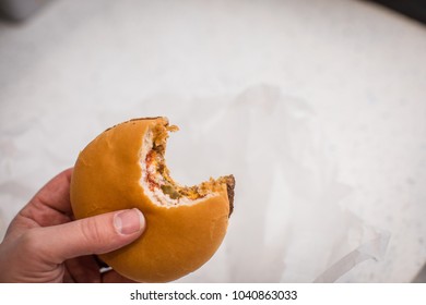 Cheese Burger In Hand With A Bite Taken Out Of It