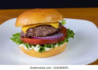 Cheese Burger With Tomatoand Red Onion On A Brioche Roll