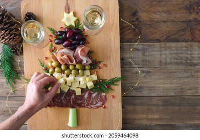 Cheese And Charcuterie Board In The Shape Of A Christmas Tree. Two People Eating. Copy Space. Top View.