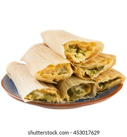 Cheese and chili tamales on plate and isolated on white background, view from eye level.
