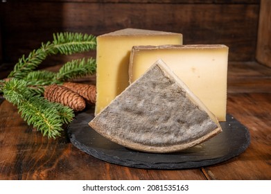 Cheese collection, French cow cheeses comte, beaufort, abondance, tomme de savoie and fir cones