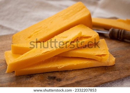 Cheese collection, piece of matured British yellow cheddar cheese made in Somerset from cow milk close up