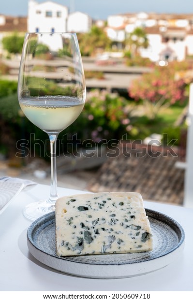 Cheese collection, semi-hard French blue\
cheese roquefort from Roquefort-sur-Soulzon, France, served with\
sweet cold white french wine, close\
up