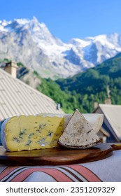 Cheese collection, Tomme de Savoie and Bleu de Savoie blue cheese from Savoy region in French Alps, mild cow's milk cheese served outdoor, mountains view in La Grave village, France