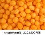 Cheese Corn balls. Texture, Pattern of Cheese flavored snack. Selective focus, food background. Cheese puff. Cinema snacks. Crunchy puffed balls.