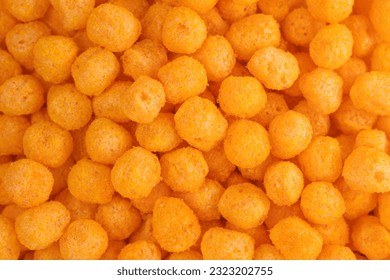 Cheese Corn balls. Texture, Pattern of Cheese flavored snack. Selective focus, food background. Cheese puff. Cinema snacks. Crunchy puffed balls.