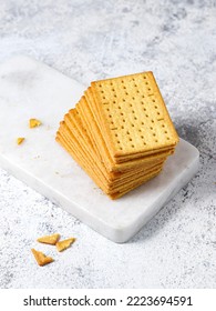 Cheese Crackers On A White Marble Cutting Board On A White Background