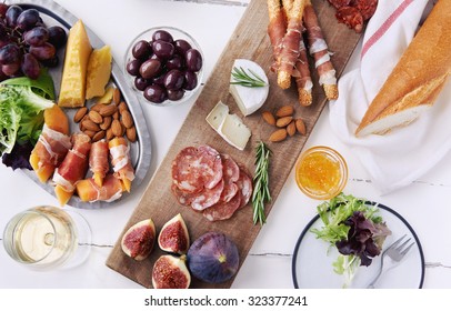 Cheese and cured meat charcuterie selection salami, chorizo, prosciutto wrapped bread sticks with fresh fig, rockmelon, almonds and white wine - Powered by Shutterstock