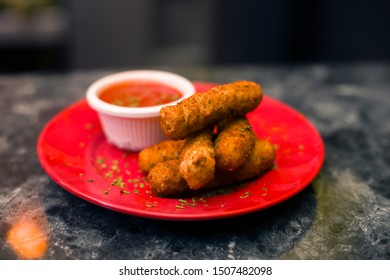Cheese Fingers With Tomato Sauce On A Red Plate