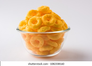 Cheese flavoured Puffs or rings closeup, served in bowl or over moody 
