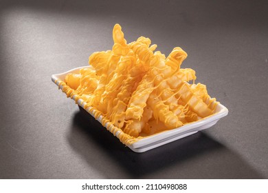 Cheese Fries Drizzle Loaded Or Potato Chips With Cheddar Cheese In White Tray Top View On Dark Grey Background