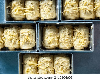 cheese and garlic bread dough in rectangle baking molds - Powered by Shutterstock