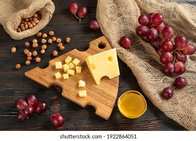 Käse, Weintrauben und Nüsse auf Holzschnittbrett