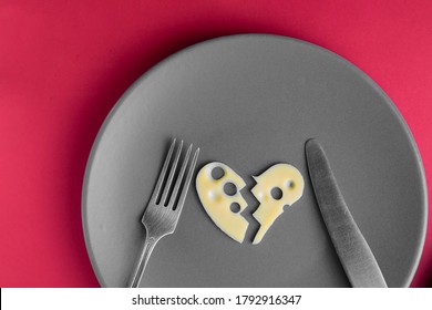 Cheese Heart Broken In Two Parts On Grey Plate With Fork And Knife On Red Background. Food Concept. Agriculture And Dairy Manufacture. Top View. Horizontal