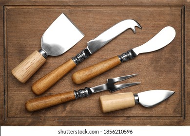 Cheese knives and fork on wooden board, flat lay - Powered by Shutterstock