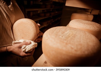 Cheese Maker Cleaning Cheeses In His Workshop