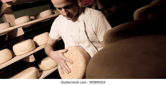 Cheese Maker Cleaning Cheeses In His Workshop