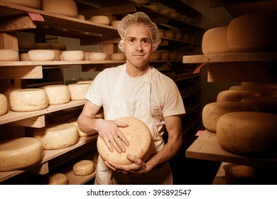 Cheese Maker Cleaning Cheeses In His Workshop