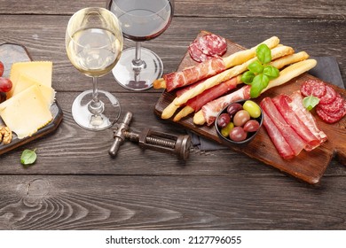 Cheese, Meat, Grapes And Olives Antipasto. Appetizer Selection Board And Glasses With Red And White Wine