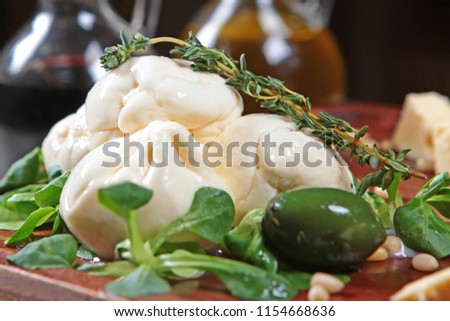 Cheese mozzarella with olives on a wooden background. Two bottles of olive oil in the background. Concept restaurant.