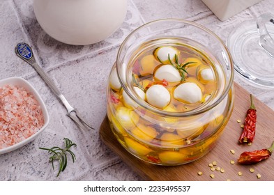 Cheese with oil and spices in a glass jar. Selective focus. - Powered by Shutterstock