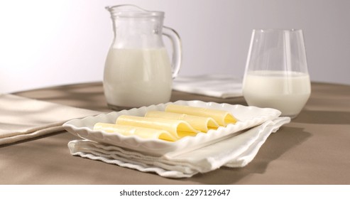 cheese on white plates with milk. dairy products on a brown background. gouda cheese close-up. slices of yellow cheese. farm product - Powered by Shutterstock