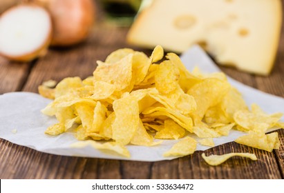 Cheese and Onion Potato Chips on rustic wooden background (close-up shot)