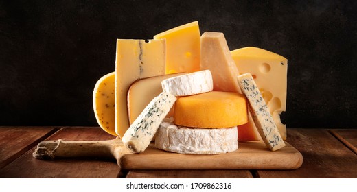 Cheese panorama, many different types of cheeses, a side view on a dark background - Powered by Shutterstock