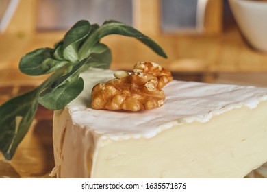 Cheese peaces on the old wooden table in the kitchen. Dairy product. Healthy eating and lifestyle.