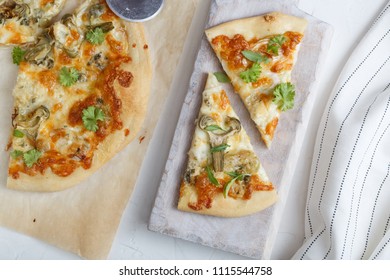 Cheese pizza with artichoke and arugula on cutting board - Powered by Shutterstock