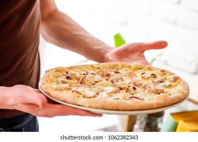 cheese pizza in the hands of a man. close-up