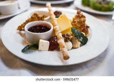 Cheese plate with cheeses Dorblu, Parmesan, Brie, Camembert and Roquefort in serving on the table