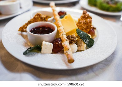 Cheese plate with cheeses Dorblu, Parmesan, Brie, Camembert and Roquefort in serving on the table