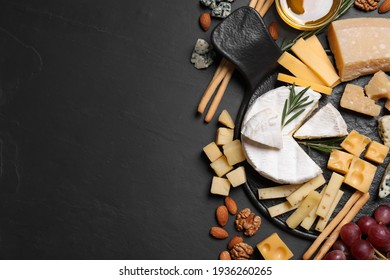 Cheese plate with honey, grapes and nuts on black table, flat lay. Space for text