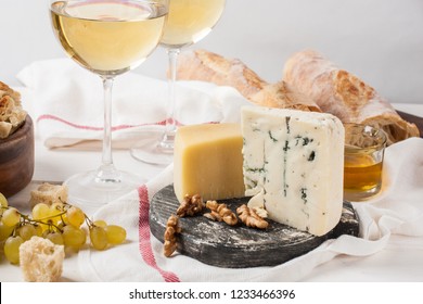 Cheese plate served with white wine, grape and nuts - Powered by Shutterstock